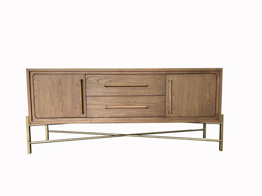 The Metal Base Sideboard - Light Brown features two central drawers, two side cabinets, gold handles, and a crisscross gold metal base, all set against a white background.