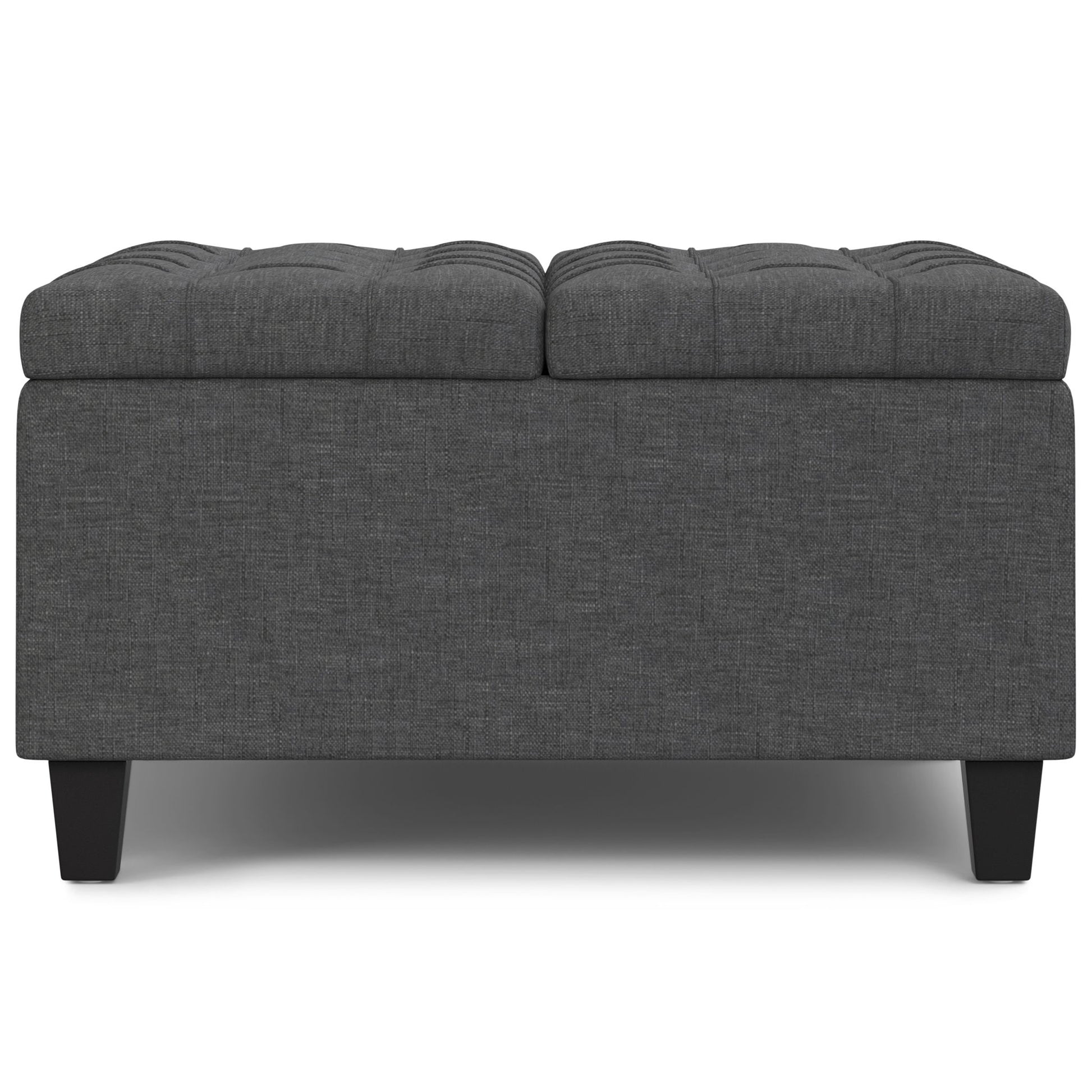The Harrison Upholstered Coffee Table Storage Ottoman is rectangular, dark gray with a tufted top and short black legs, pictured against a white background.