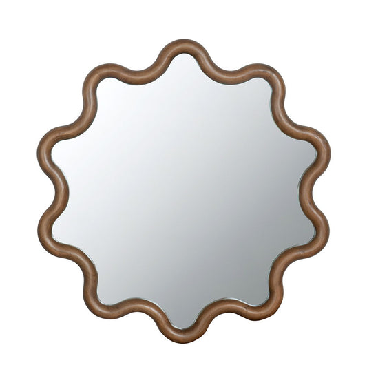 The Wooden Accent Mirror features a brown, wavy sculpted frame with a flower or sunburst design, perfect for living rooms, bedrooms, or entryways. Displayed against a plain white background.