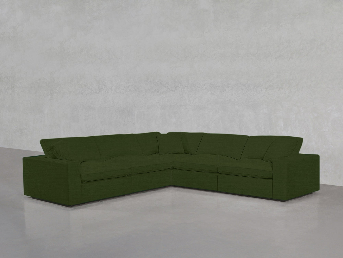 A 5-Seat Modular Corner Sectional with deep cushions and a modern, minimalist design sits on a smooth grey floor against a plain light grey wall.