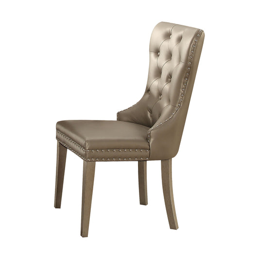 The Kacela Synthetic Leather Side Chair (Set of 2) in Champagne features light brown tufted upholstery, silver nailhead trim, and wooden legs, displayed at an angle on a white background.