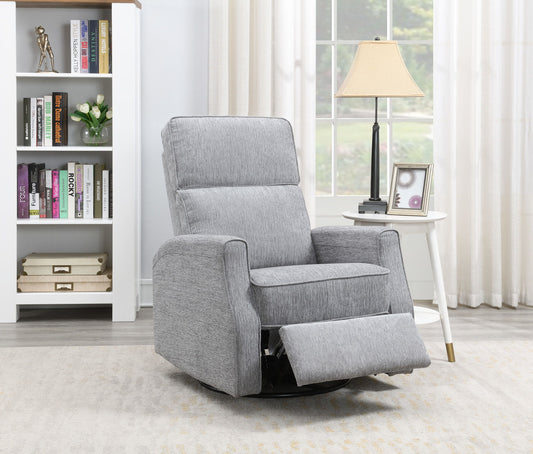 The Tavor Swivel Gliding Recliner, in light gray upholstery with an extended footrest, sits in a living room beside a white round side table holding a lamp and photo frame, with a bookshelf and window in the background.