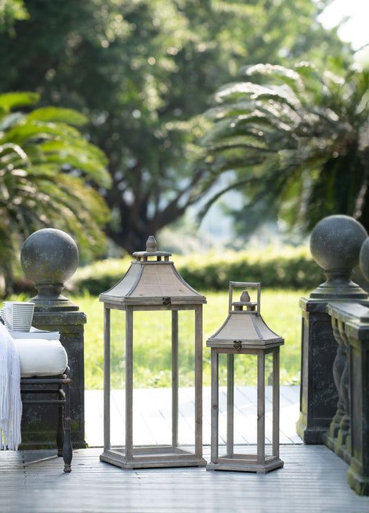 A group of Candle Lantern Decorative Hurricane Lantern Holder Decor in ivory arranged on a deck for indoor or outdoor use at home, garden, or wedding.