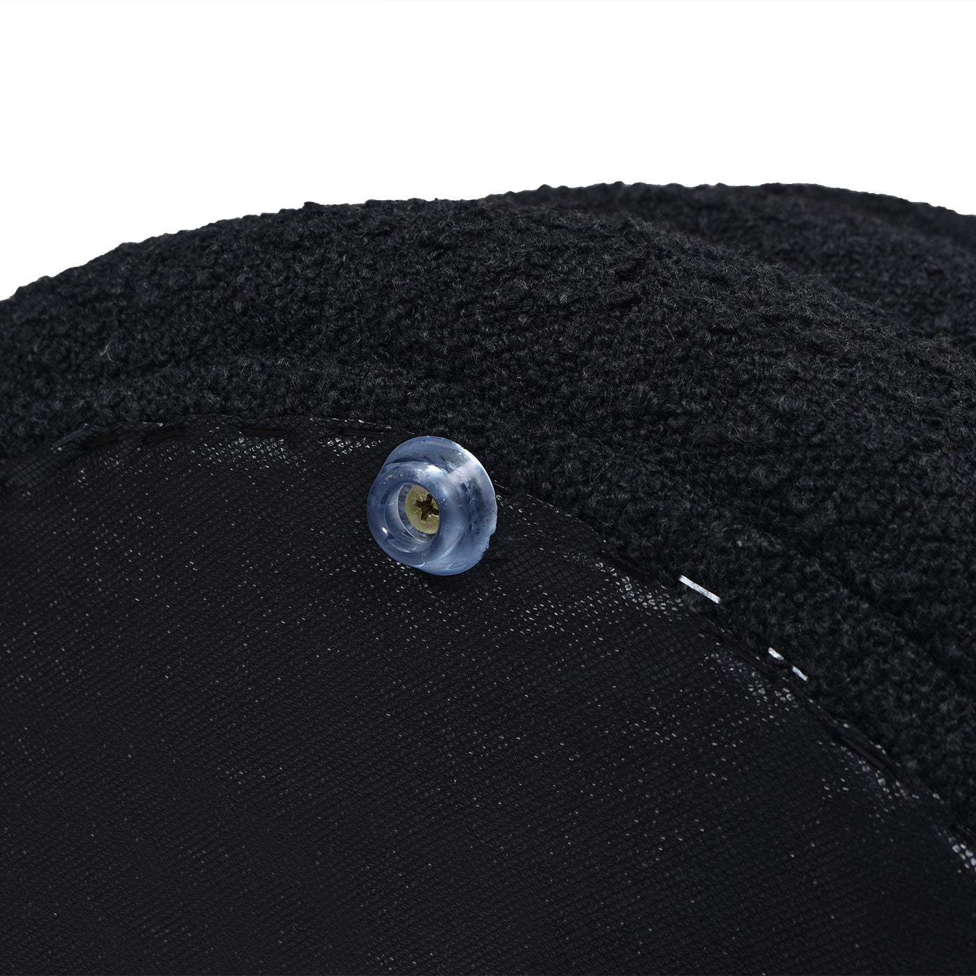 Close-up of a blue translucent button sewn onto the textured black fabric of the Fuji - Oversized Round Storage Ottoman, with visible stitching and soft, thick material.