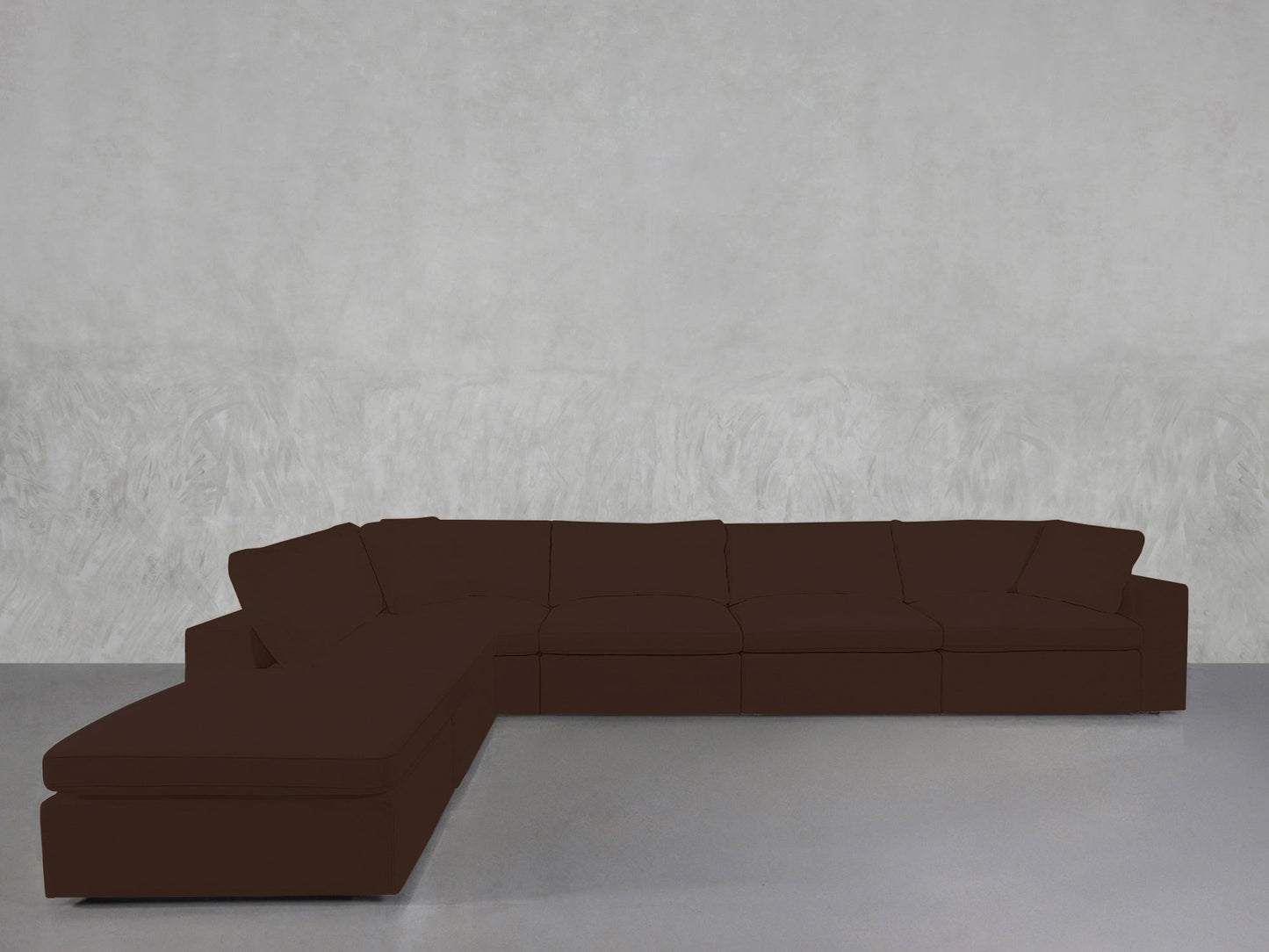 A spacious dark brown 6-Seat Modular Corner Lounger Sectional with cushions sits against a plain, light gray textured wall and a smooth gray floor.
