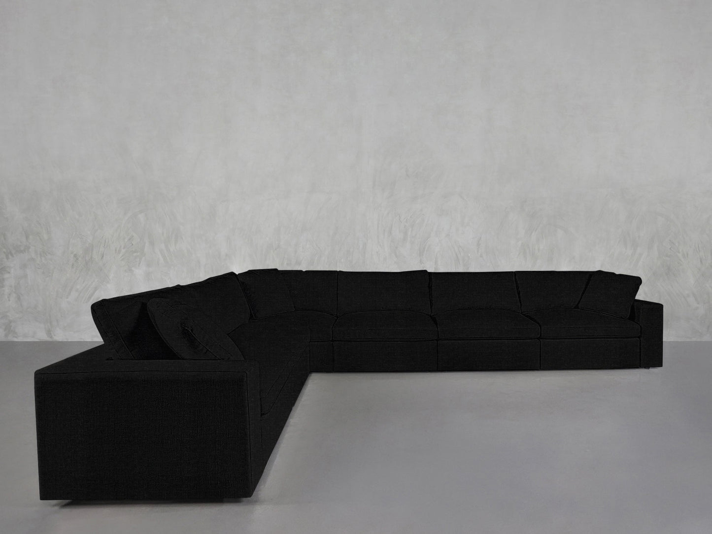 A 6-Seat Modular Corner Sectional in black with modern clean lines sits against a light gray textured wall atop a smooth, light gray floor.