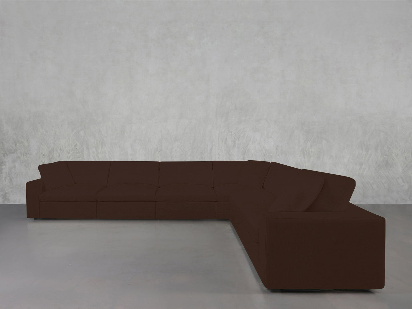 A 6-Seat Modular Corner Sectional in dark brown with clean lines sits on a light gray floor against a pale textured wall in a minimalist room.