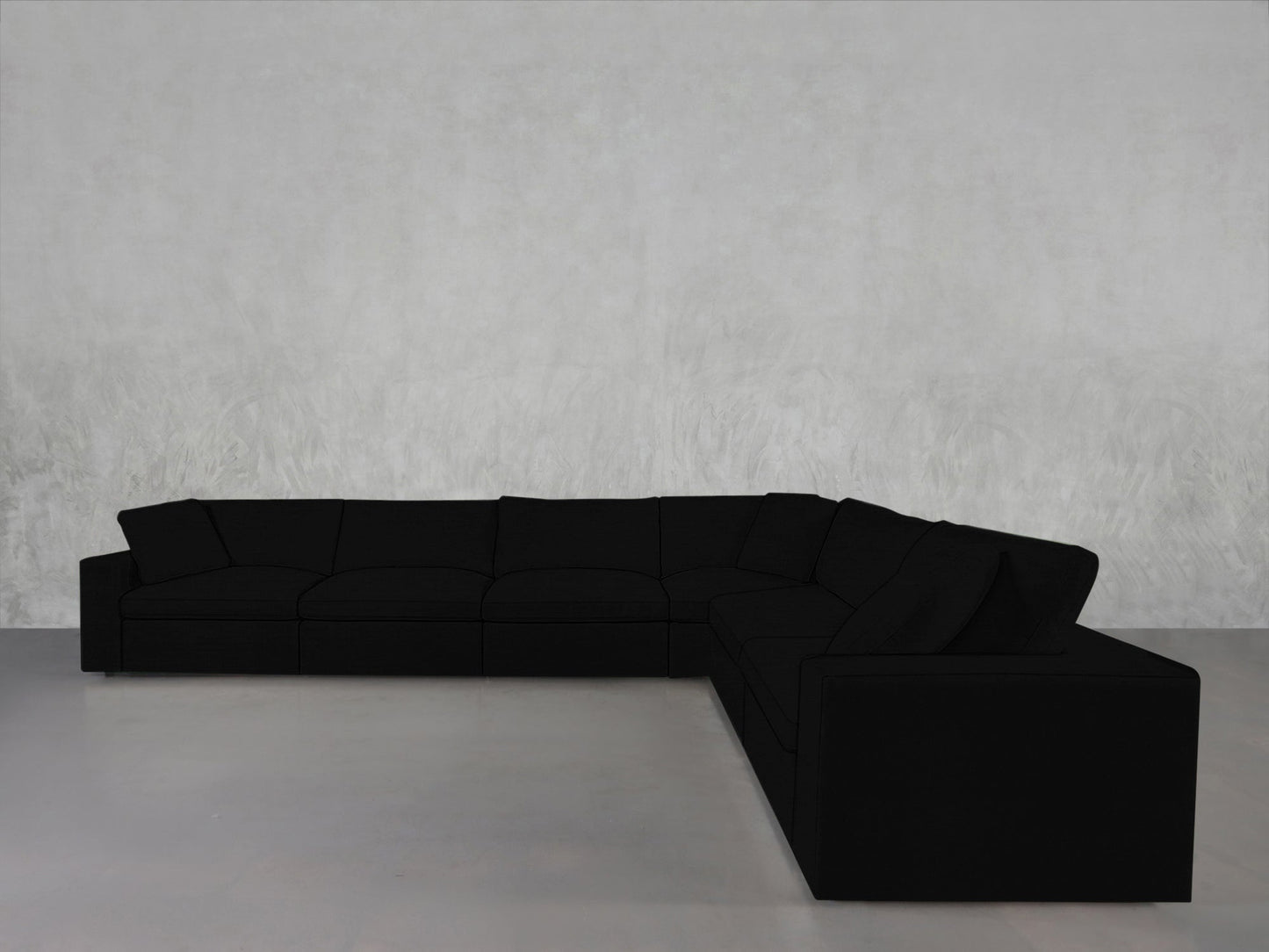 A 6-Seat Modular Corner Sectional in modern black with clean lines sits against a light gray textured wall on a smooth, light-colored floor.