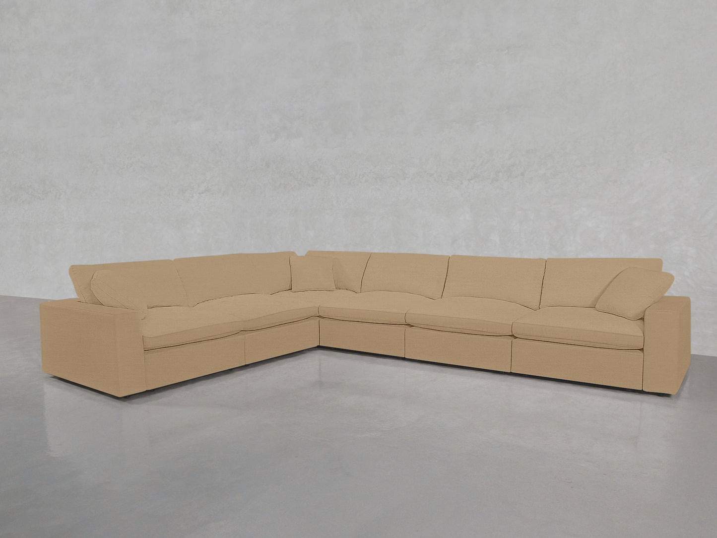 A 6-Seat Modular Corner Sectional with plush cushions in beige is placed in an empty room featuring light gray walls and a polished concrete floor.