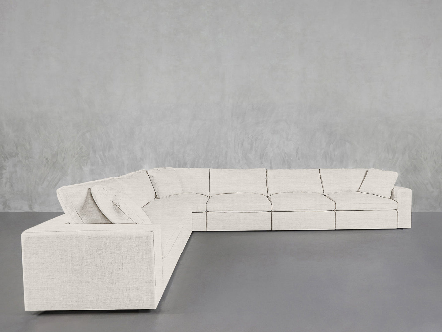A 6-Seat Modular Corner Sectional with clean lines and a light gray minimalist design sits against a gray wall on a matching floor, featuring five seat cushions.