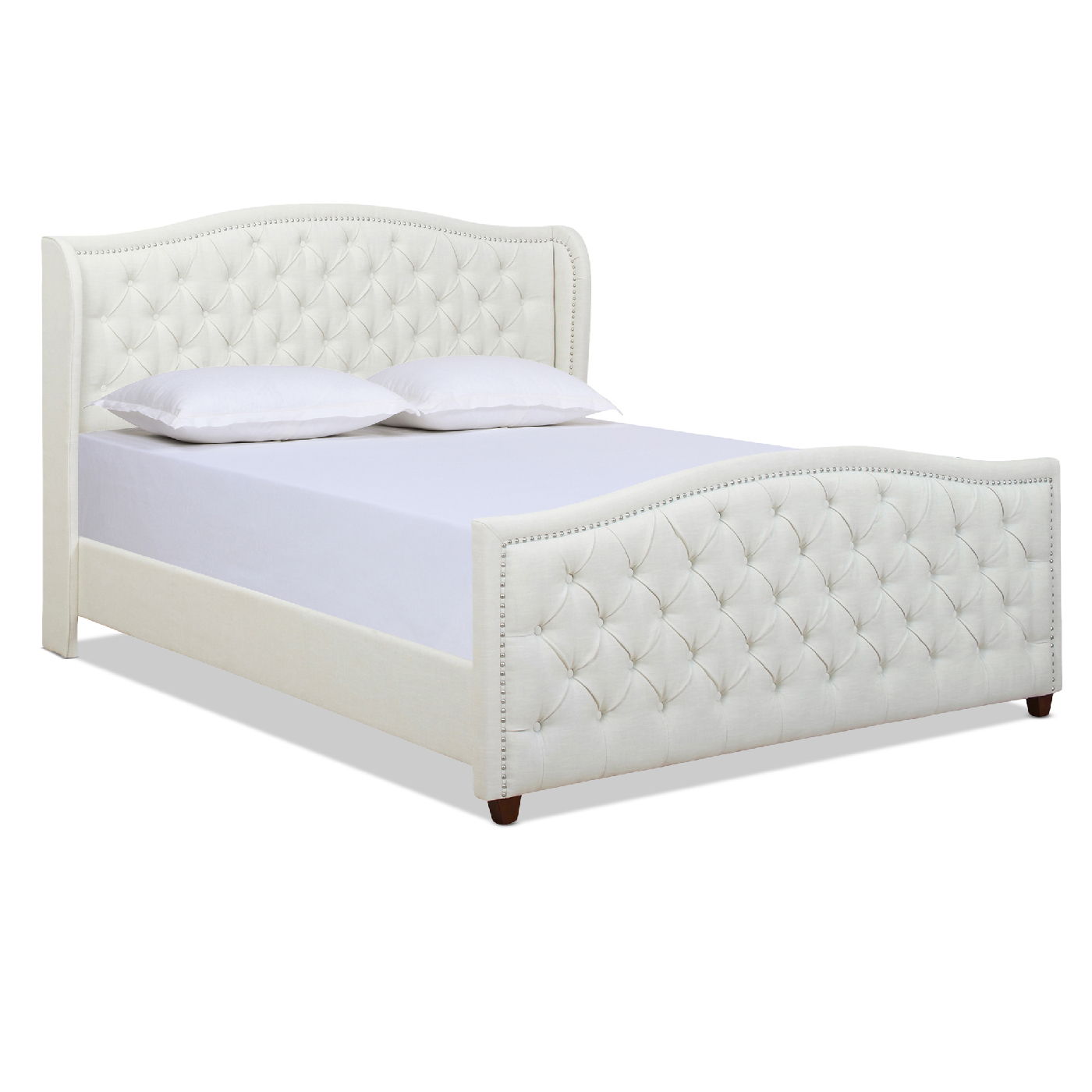 The Marcella - Upholstered Shelter Headboard Bed Set features a white tufted headboard and footboard with nailhead trim, two white pillows on a white mattress, and stands on short, dark wooden legs.