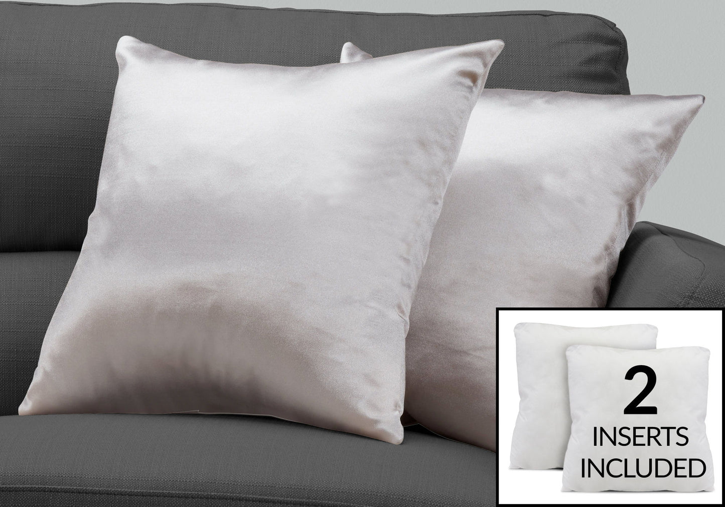 Two light gray satin decorative throw pillows from Modern come with two white, hypoallergenic inserts. The square pillows are displayed on a dark gray sofa. Text inset: "2 INSERTS INCLUDED.