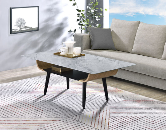 A modern living room with a light gray sofa, the Landon Coffee Table with glass marble texture top and bent wood design featuring a tray with teapot and cups, a geometric-patterned rug, a plant, and framed tree artwork on the wall.