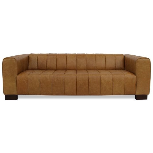 The Dixon - Waxy Sofa - Tan features a modern design with wide square arms, vertical tufted cushions, and dark wooden block legs, shown against a white background.