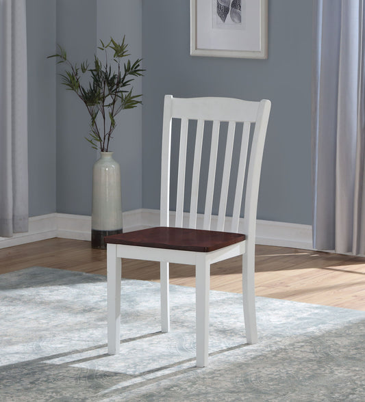 The Leigh Side Chair (Set of 2) in White features a white frame and dark brown seat, placed on a light-patterned rug in a room with pale blue walls, wood floors, framed artwork, and a potted plant.