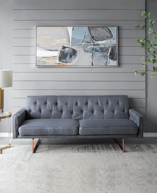A modern living room with a gray tufted sofa, the Large Modern Oil Painting (Multicolor) above, a floor lamp to the left, a side table, and a leafy plant on the right, set against gray shiplap walls and a light rug.