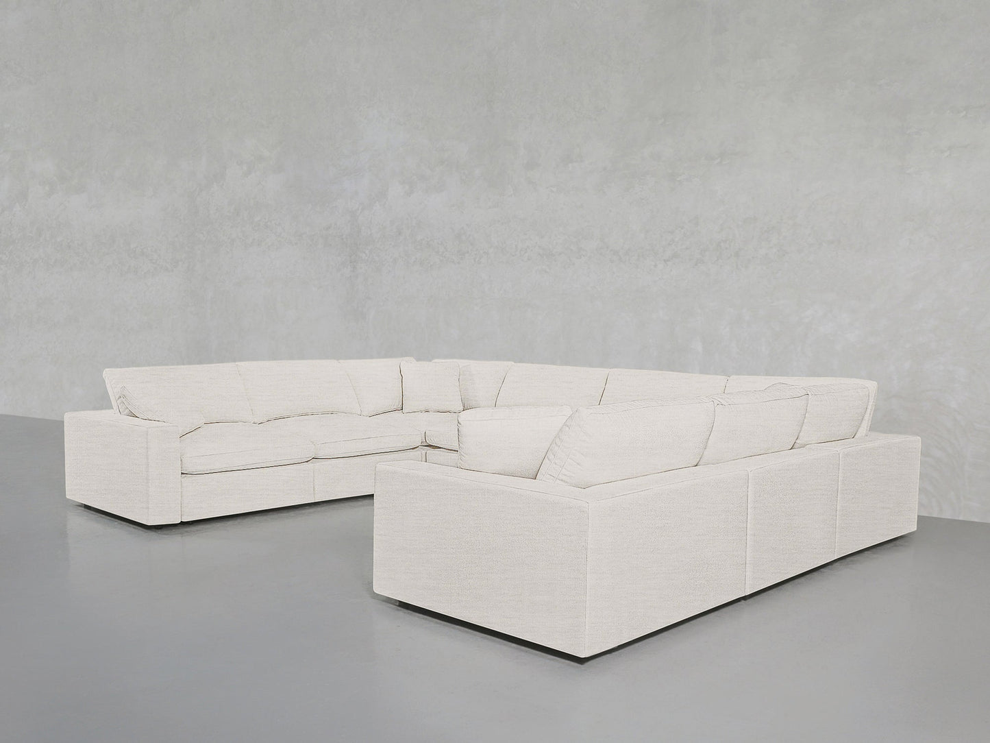 The 8-Seat Modular U-Sectional in light beige, featuring clean lines and deep cushions, stands out against a minimalist grey wall and floor for a spacious, contemporary look.