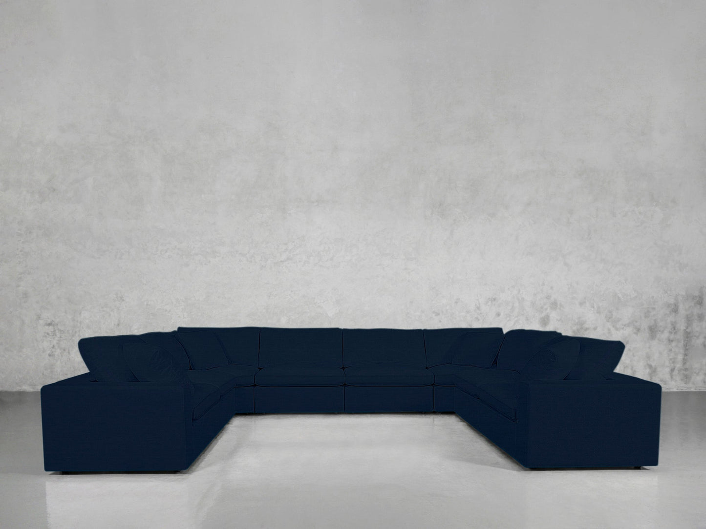 An 8-Seat Modular U-Sectional in dark blue is placed in an empty room with light gray textured walls and a shiny, light-colored floor.