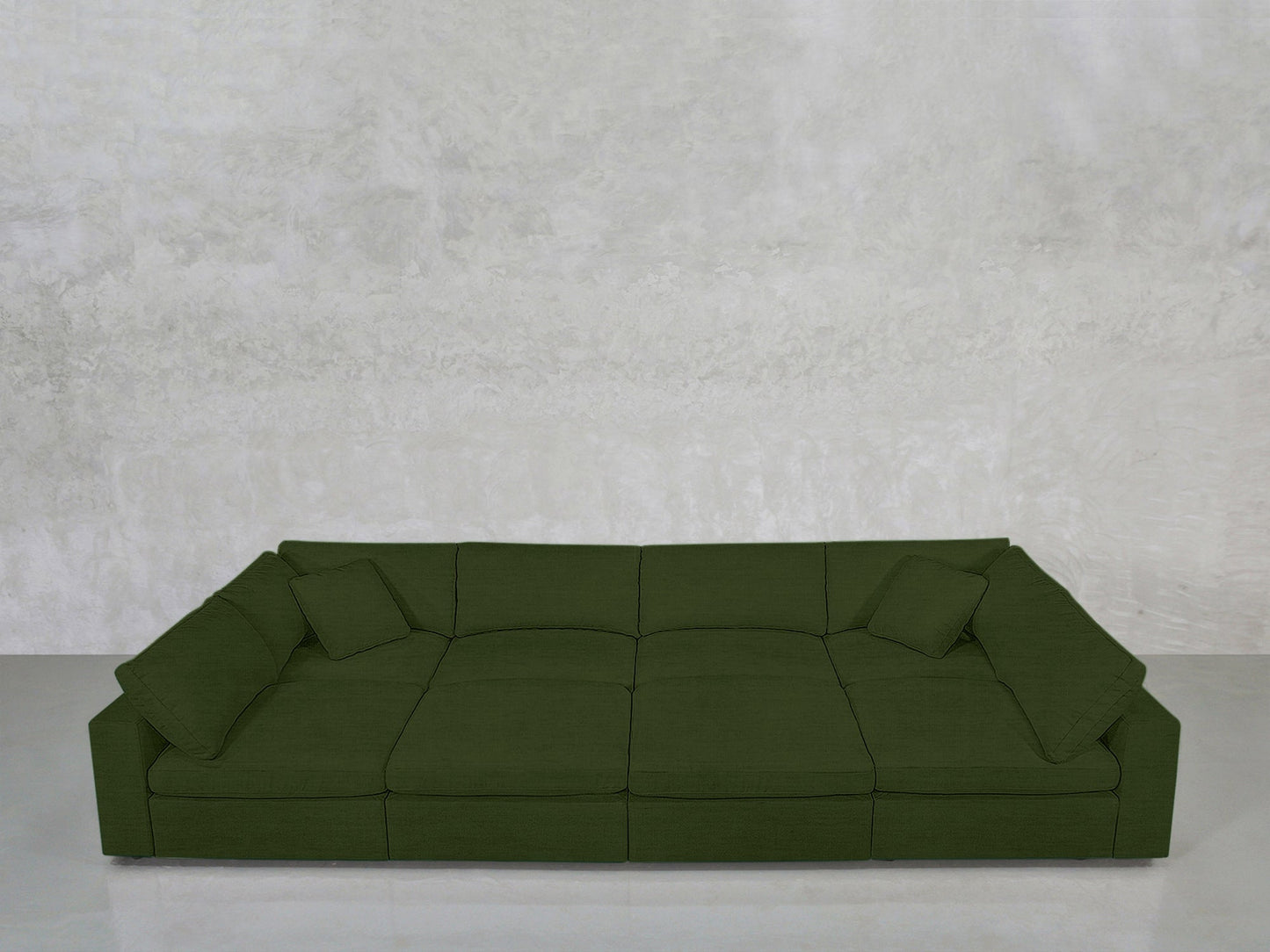 An 8-Seat Modular Pit in olive green with low arms and three cushions sits against a textured light gray wall on a polished light gray floor.