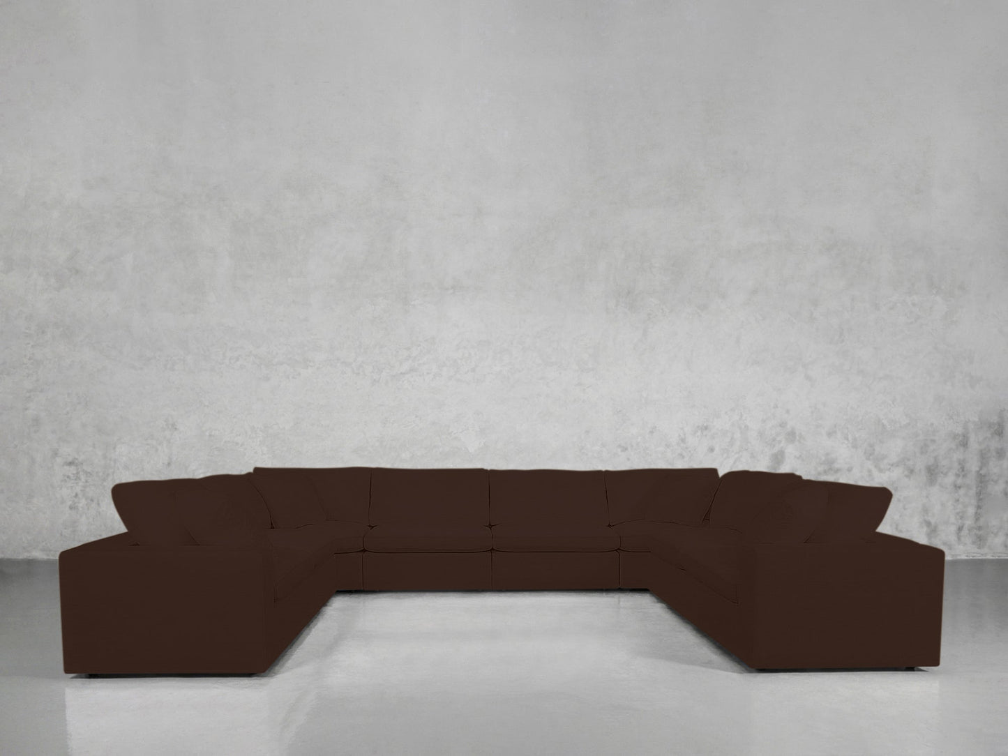 An 8-Seat Modular U-Sectional in dark brown is arranged in a U-shape against a plain, light gray textured wall and a shiny, reflective floor.