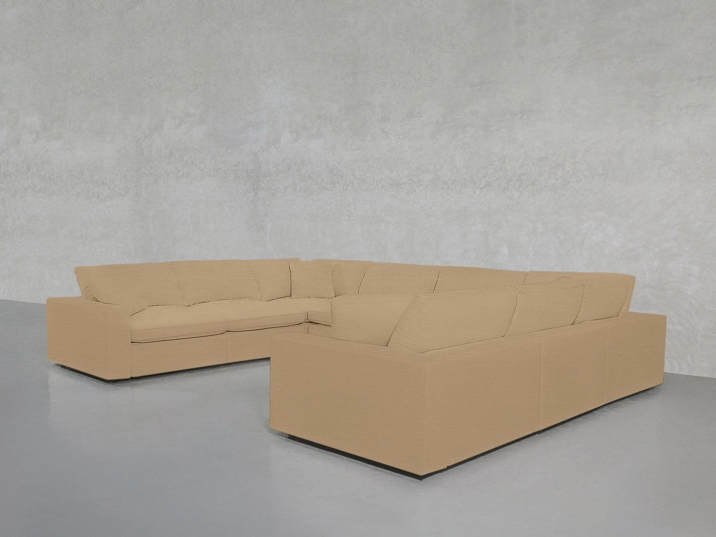 An 8-Seat Modular U-Sectional with thick beige cushions sits against a light gray textured wall on a gray floor in a modern minimalistic room.