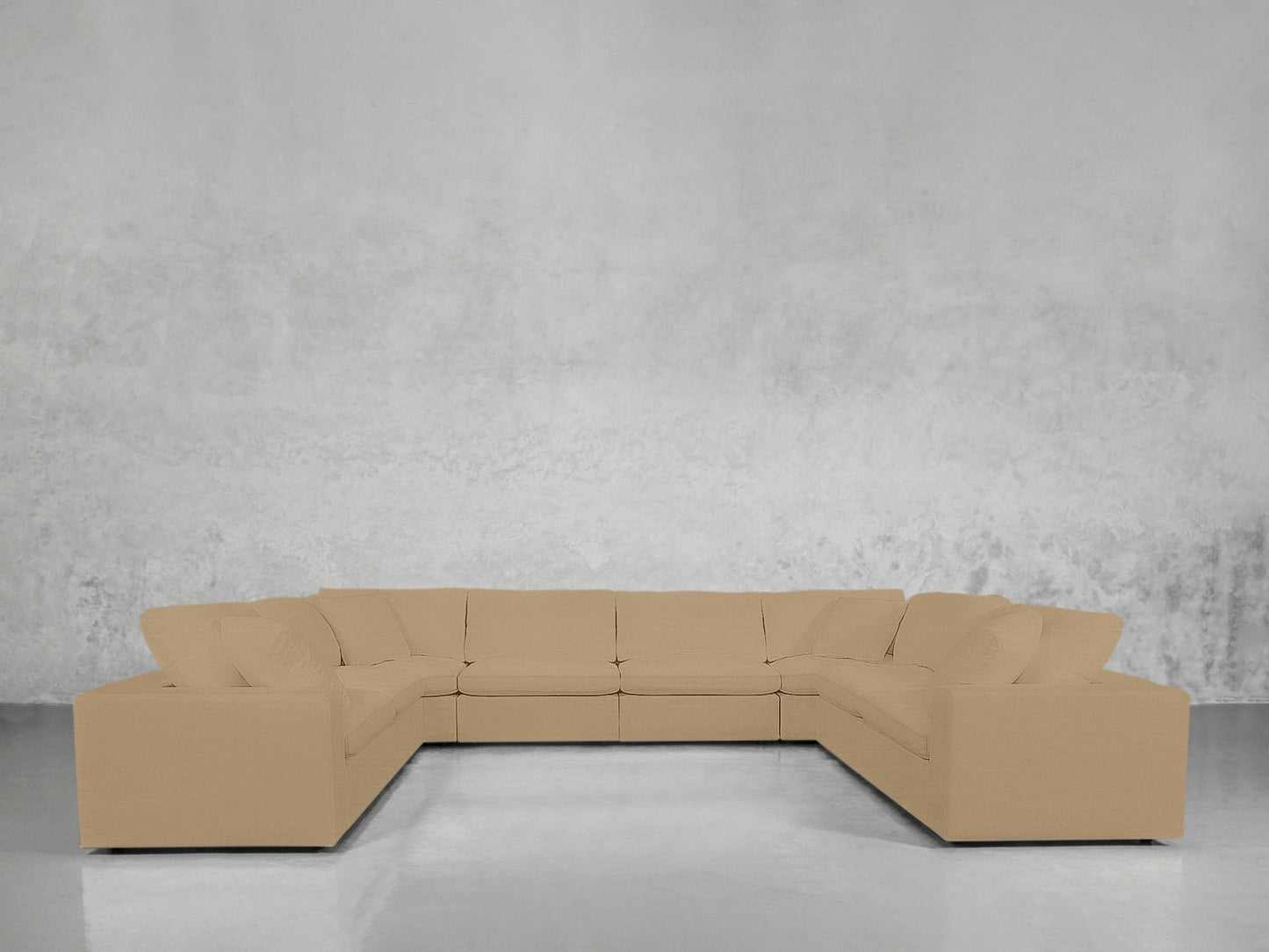 An 8-Seat Modular U-Sectional in beige with cushions is set against a plain light gray wall on a polished floor.
