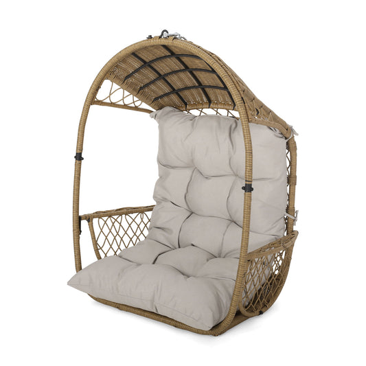 The Malia - Wicker Hanging Chair With Cushion features a domed frame, beige tufted seat and backrest cushions, and open woven sides—perfect for relaxing or lounging.