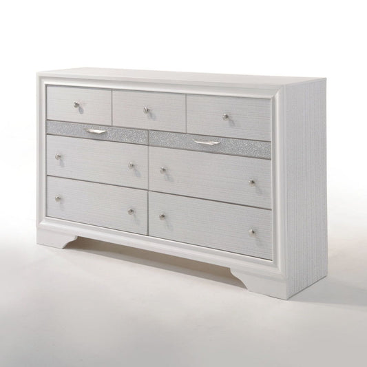 The Naima Versatile Storage Dresser is a white wooden piece with seven drawers, silver handles, and a glittery silver-accented central drawer, displayed against a plain white background.