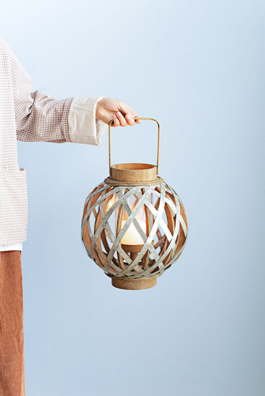 A person holds the Decorative Lantern With Handle, Wooden Lantern For Indoor Outdoor, Home Garden, Wedding - Silver against a pale blue background.
