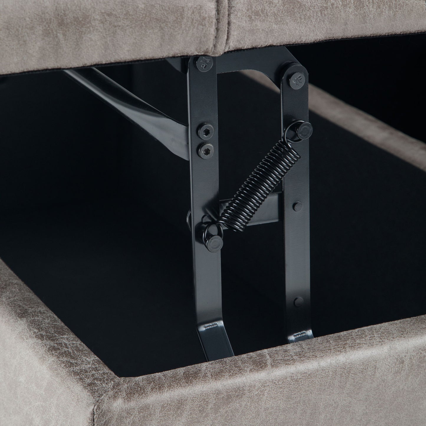 Close-up of the metal hinge and spring mechanism inside the Harrison - Upholstered Coffee Table Storage Ottoman, highlighting the opening hardware beneath its lifted cushioned lid.