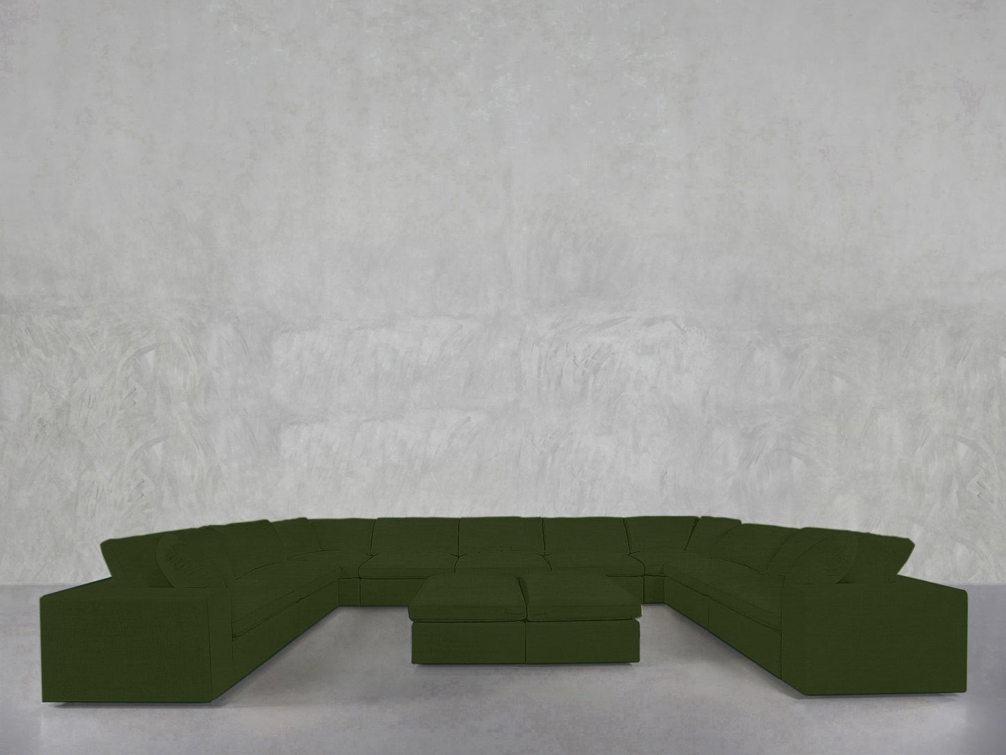 A 9-Seat Modular U-Sectional with Double Ottoman, in dark green, sits on a light gray floor against a textured pale gray wall.