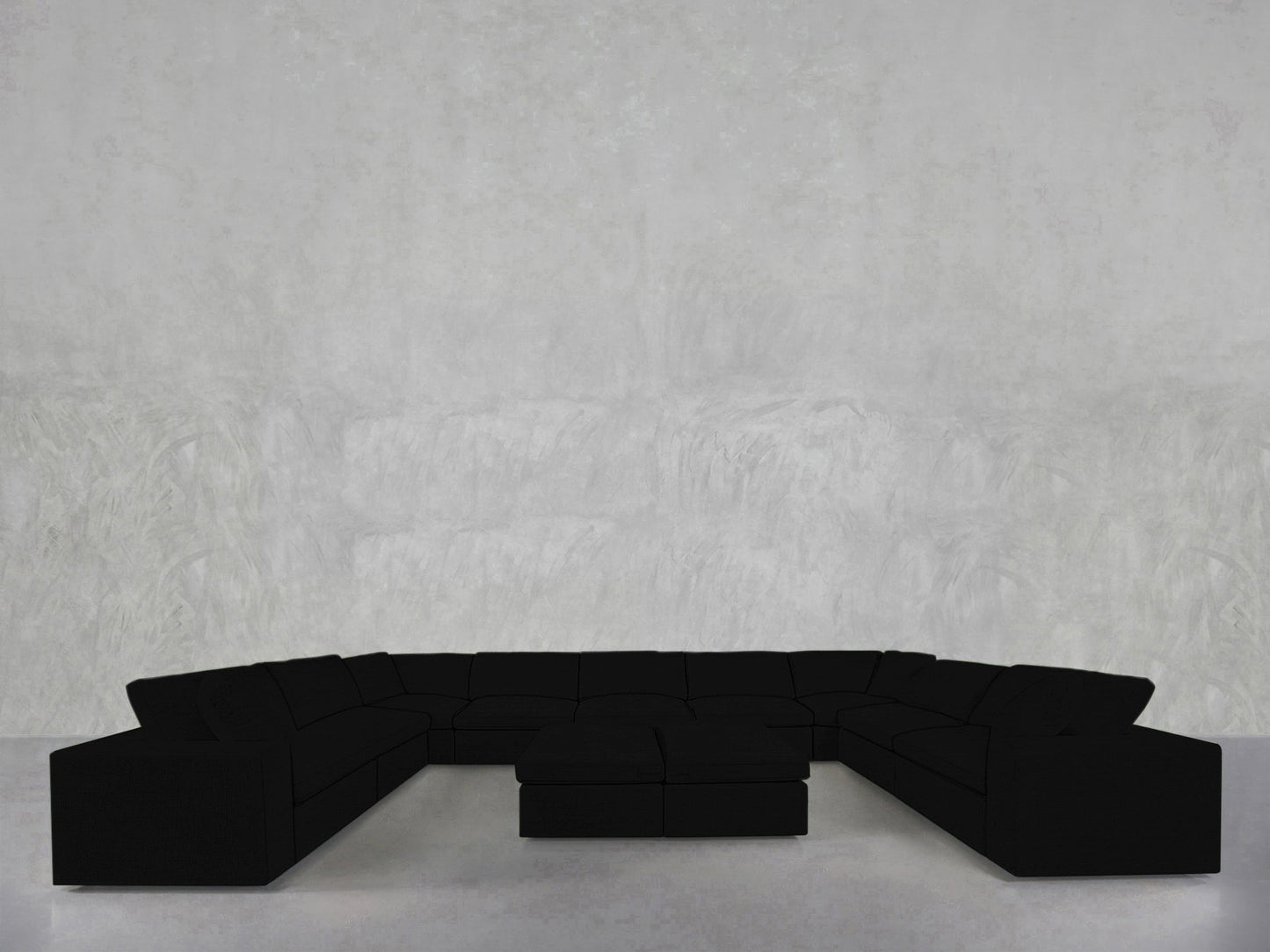 A 9-Seat Modular U-Sectional with Double Ottoman is arranged in a spacious, minimal room featuring light gray textured walls and a sleek light floor.