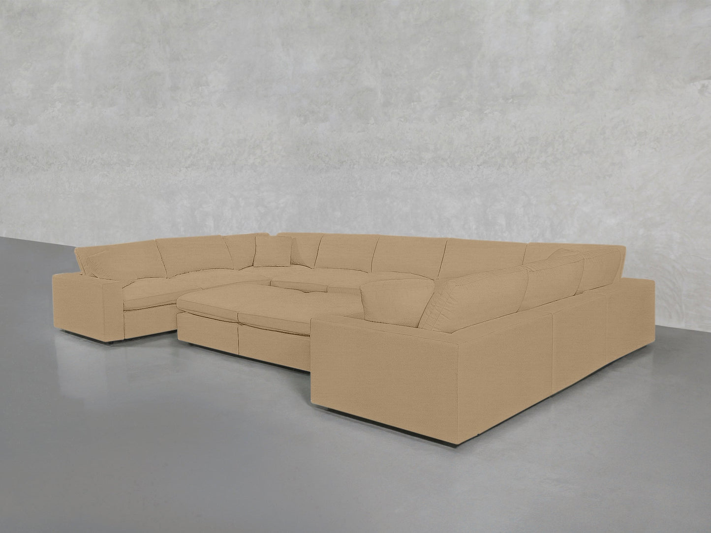 A spacious 9-seat modular U-sectional with double ottoman, in beige, features wide seats and plush cushions; it's arranged on a gray floor against a light gray textured wall.