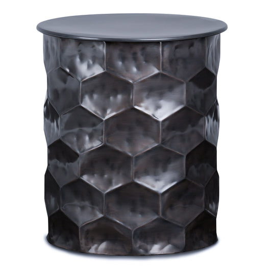 The Whitney - Handcrafted Metal Storage Table is a cylindrical piece with a dark, shiny finish and a textured honeycomb pattern on the sides. It features a smooth, flat top for display or use.