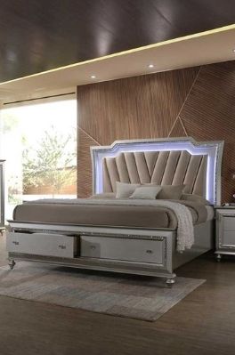 A modern bedroom with the Kaitlyn Bed featuring LED lighting, a geometric headboard, built-in storage drawers, neutral bedding, and matching nightstands, set against a wood-paneled accent wall.