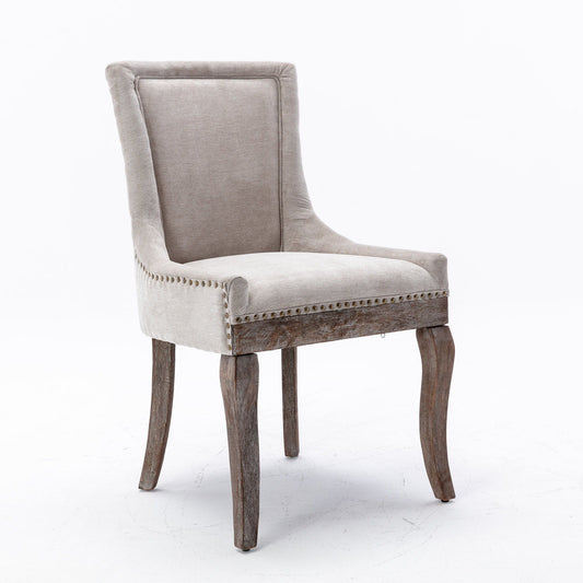 The Ultra Side Dining Chair features thickened beige fabric, neutrally toned solid wood legs, and bronze nailhead trim, presented against a plain white background. Set of 2.