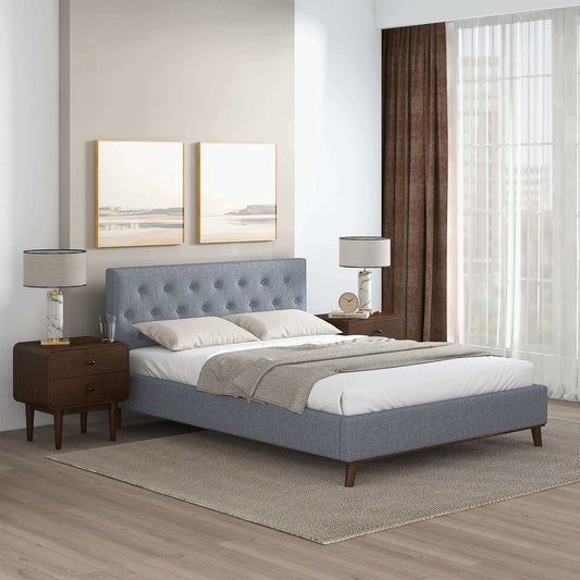 A modern bedroom featuring the Graceville - Elegant Design Platform Bed with gray upholstery, white bedding, two wooden nightstands with lamps, large windows with brown curtains, and two landscape paintings above the bed.