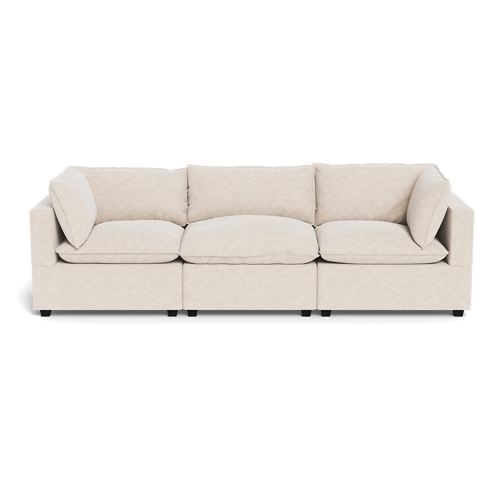 The Kova Pillow Cushion Sofa 122" is a modern three-seater with light beige upholstery, square arms, three seat and back cushions, and two matching throw pillows, displayed against a white background.