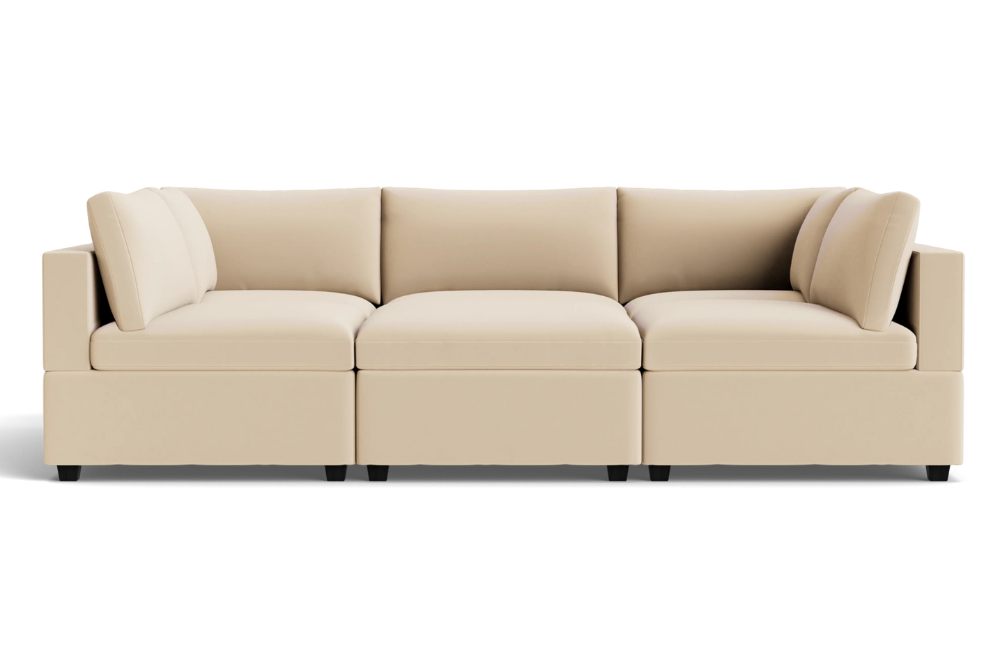 The Kova Box Cushion Pit is a modern beige sectional sofa with three seat cushions, six back cushions, and square arms, set against a plain black background.
