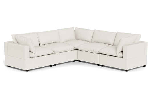 The Kova Pillow Cushion Corner Sectional is a spacious L-shaped sofa featuring cream upholstery and plush back and seat cushions.