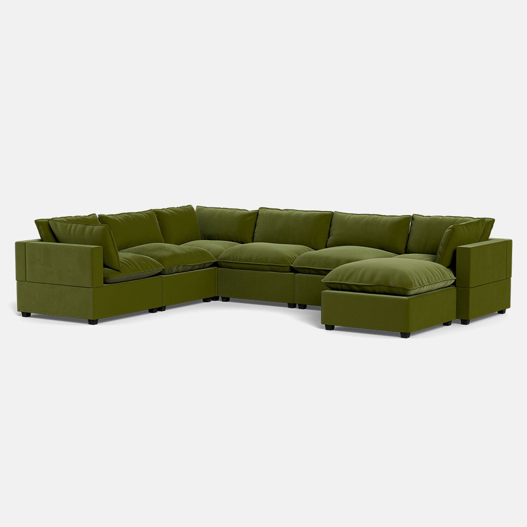 The Kova Pillow Cushion Grand Corner + Ottoman is a spacious, contemporary L-shaped sectional with a chaise lounge, wide armrests, thick cushions, and stylish olive green upholstery.
