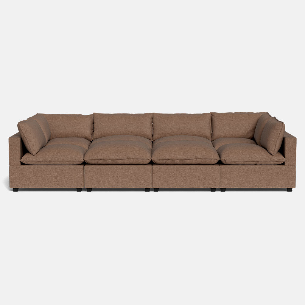 The Kova Pillow Cushion Grand Pit is a large, brown, modular sectional sofa with six seat and six back cushions, displayed against a plain white background.