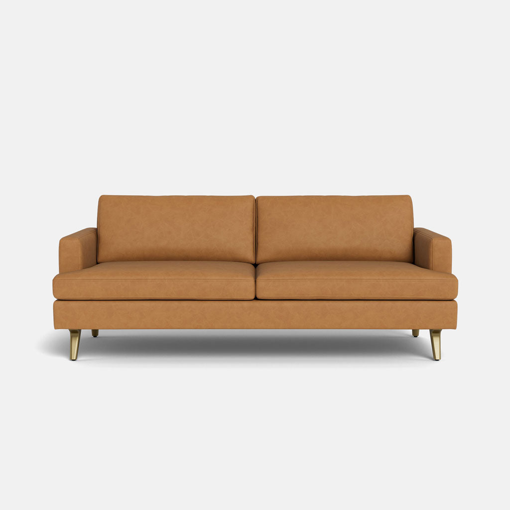 The Lido Sofa 75" is a modern tan leather sofa featuring two seat and back cushions, straight armrests, and angled wooden legs, displayed against a plain white background.