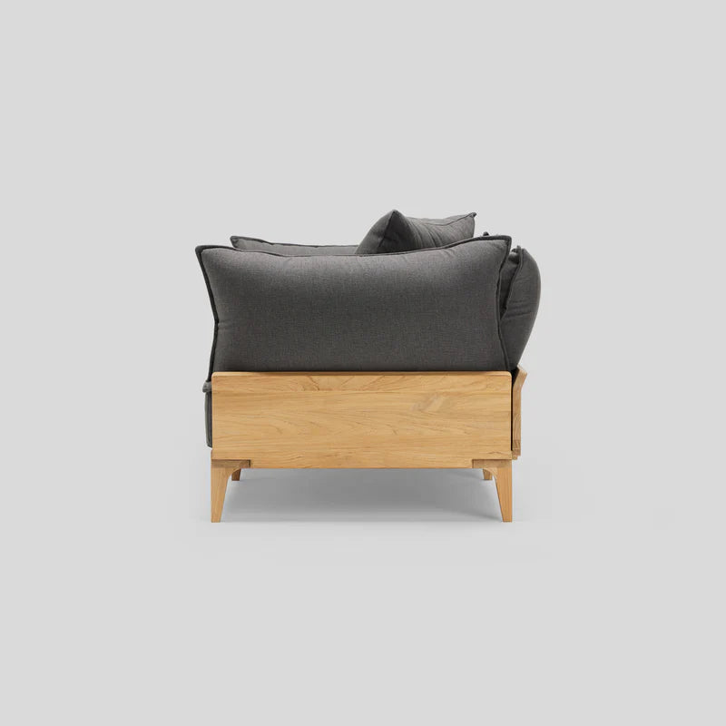 Side view of the Bluff Loveseat, featuring dark cushions and a light wooden frame, set against a plain white background.