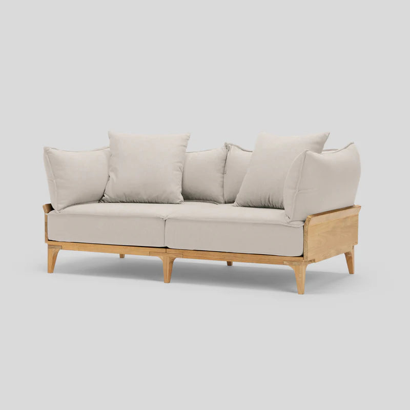 The Bluff Loveseat is a modern piece featuring wooden legs and a minimalist design. It comes with four large cushions and a sturdy frame, showcased against a plain light background.