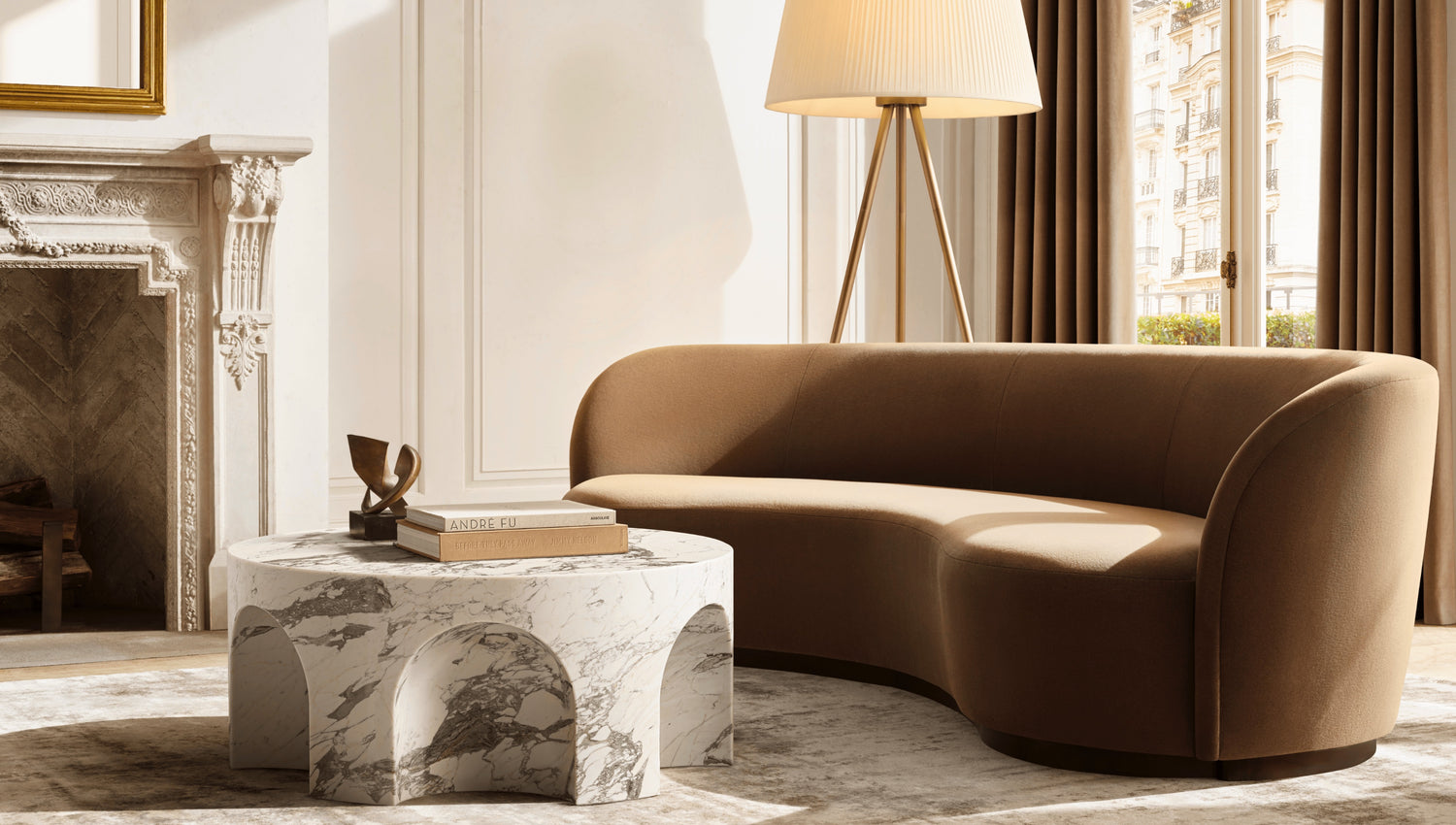 A modern living room featuring a curved brown sofa, a marble coffee table with arched details, and a tall floor lamp. The room has a decorative fireplace, a large window with brown curtains, and natural light streaming in. A book and small sculpture sit on the table.
