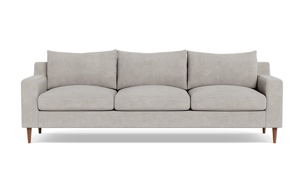 The Sloan Custom 3-Seat 95" Sofa features a modern design with a light gray finish, encompassing three seat cushions and three back cushions. Its clean, simple lines and wooden legs contribute to its minimalist and stylish look. The sofa is presented against a plain black background.