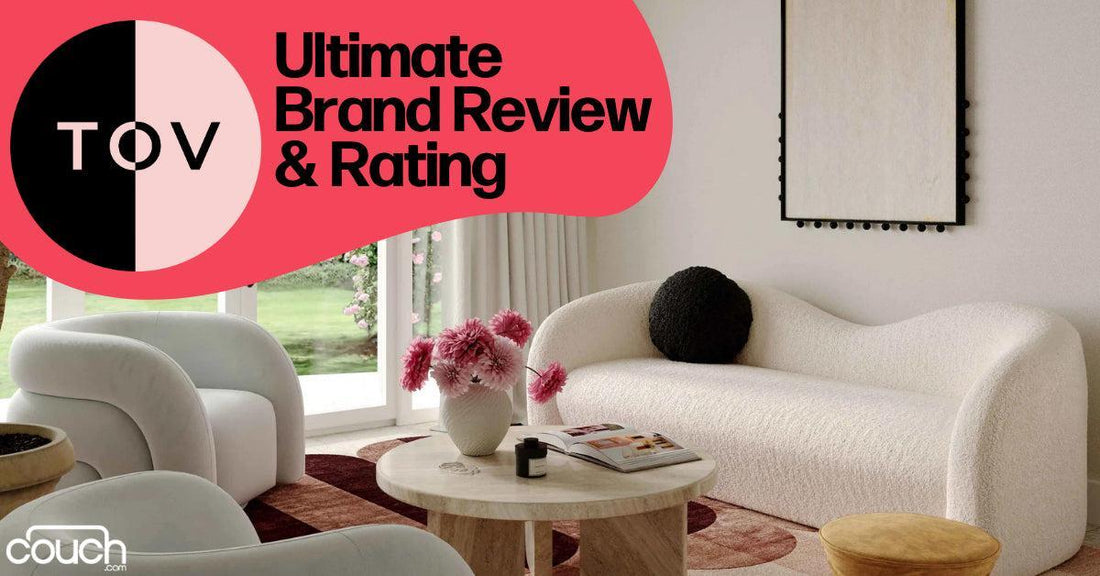 A modern living room featuring a stylish white sofa, a round wooden coffee table with pink flowers, and a large window. The text reads "Ultimate Brand Review & Rating" with "TOV" and "couch.com" logos.