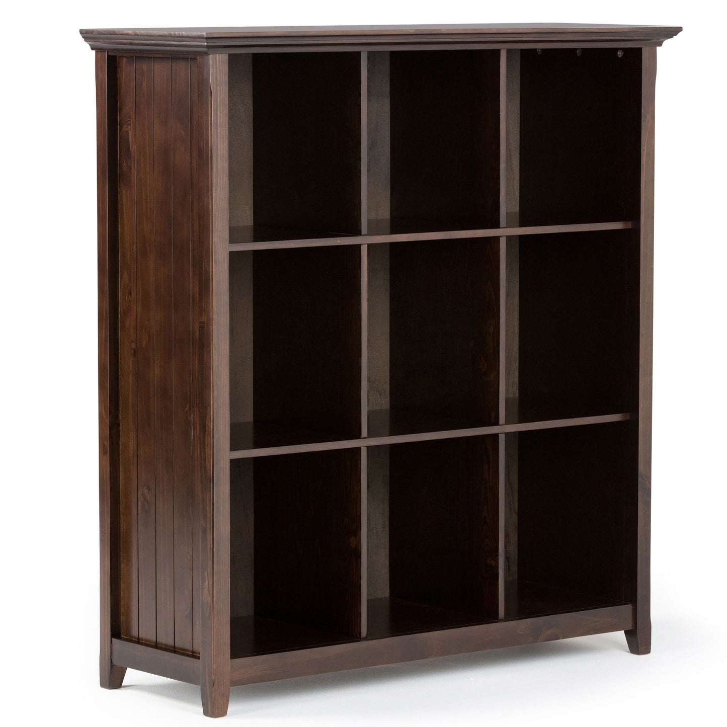 The Acadian - Handcrafted Cube Storage is a dark wooden bookcase with three shelves forming nine open square compartments, standing on four short legs and featuring vertical panel detailing on the back and sides.
