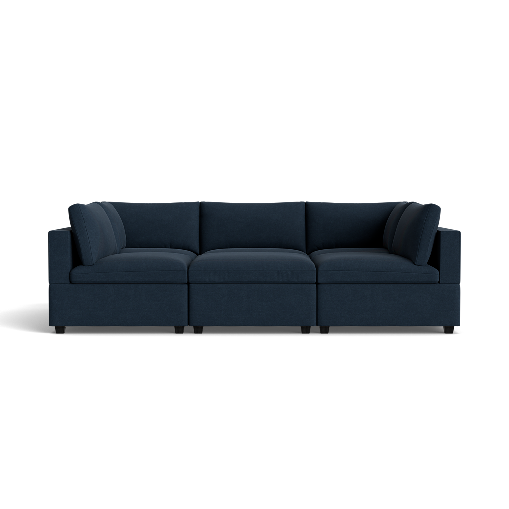 The Kova Box Cushion Pit is a modern deep blue sectional with three main seats, square arms, and thick cushions, displayed against a plain black background.